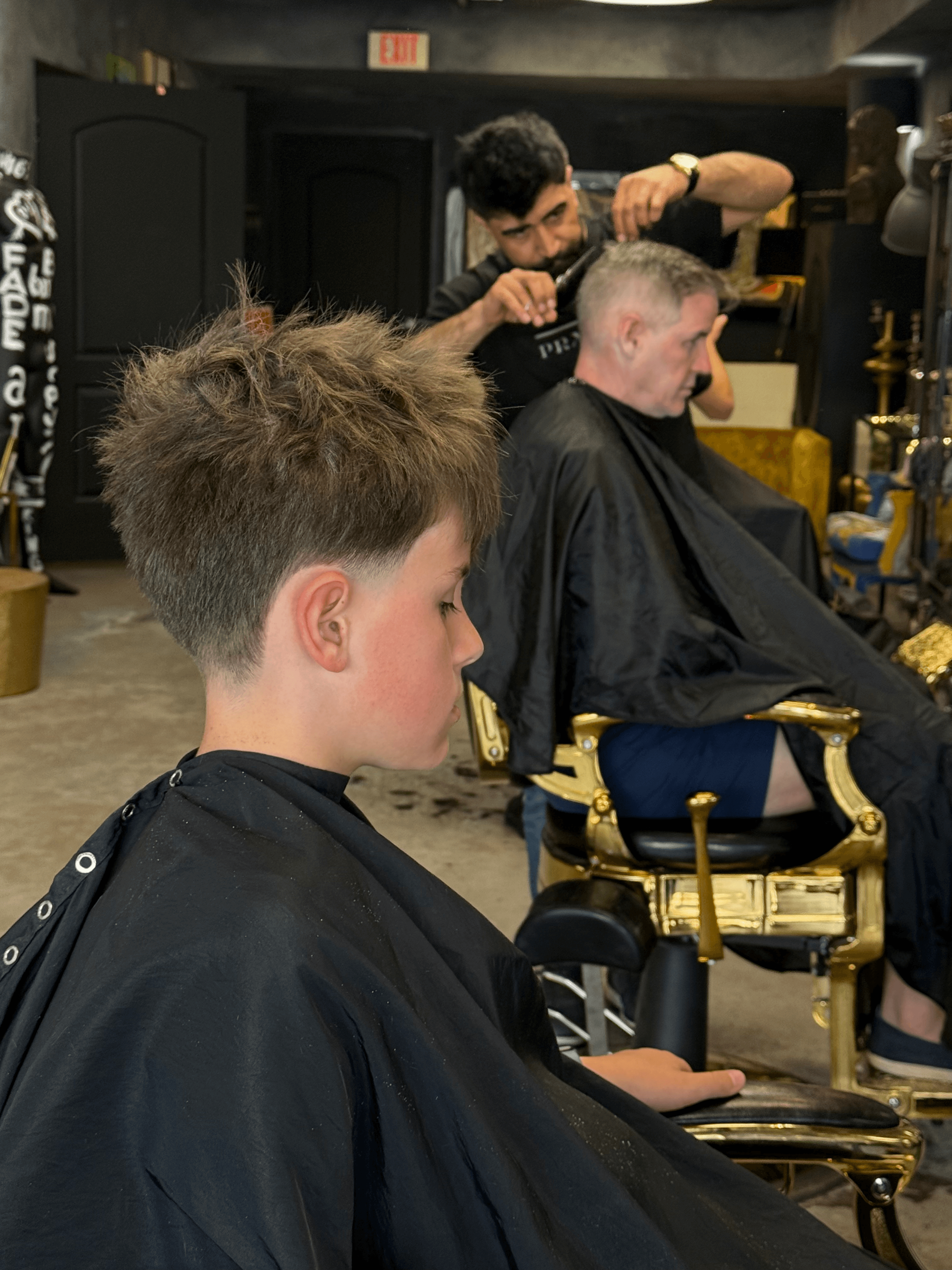 Father and son getting cuts side by side